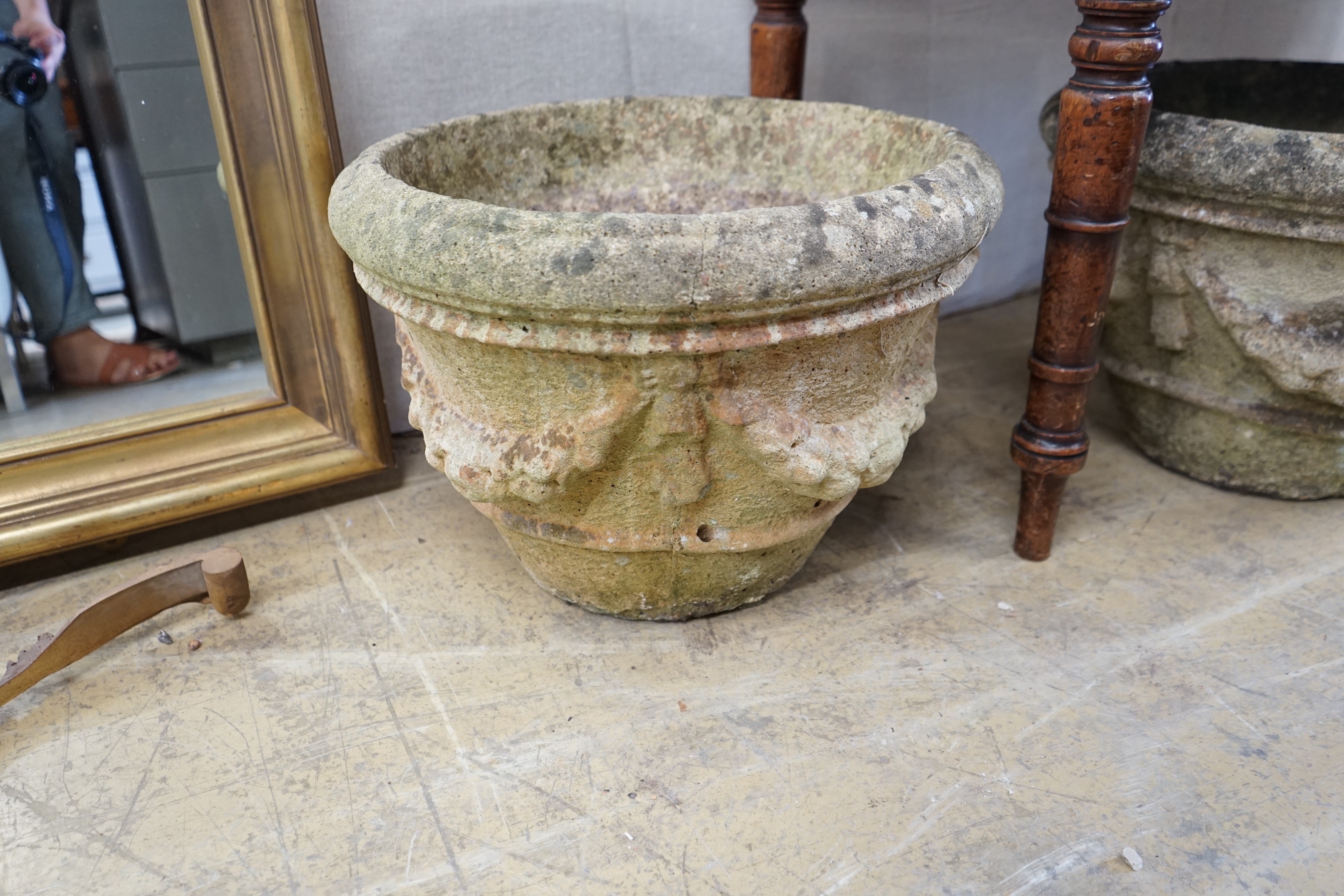 A pair of circular reconstituted stone garden urns with swagged floral bodies diameter 46cm height 33cm